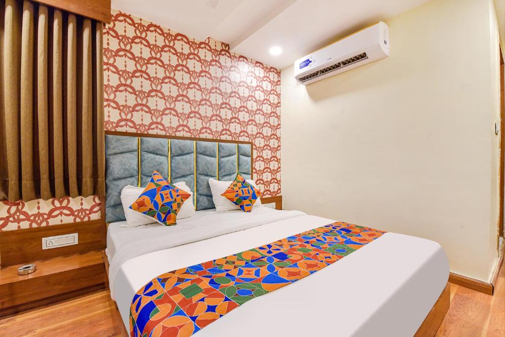 a bedroom with a large bed with a colorful blanket at FabExpress Md in Vadodara