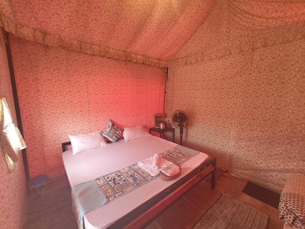 a small bedroom with a bed in a tent at TENTFORTABLE Village Retreat in Agra