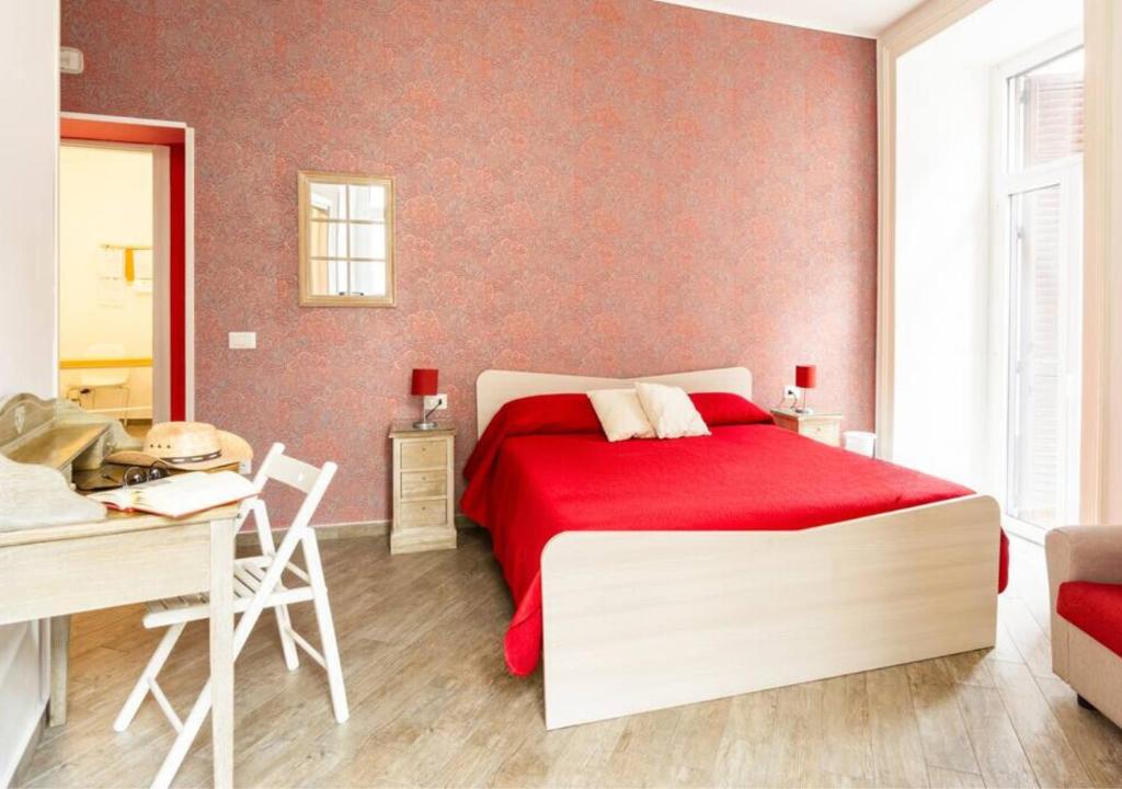 um quarto com uma cama vermelha e uma secretária em B&B da Ary Colorful Rooms em Nápoles