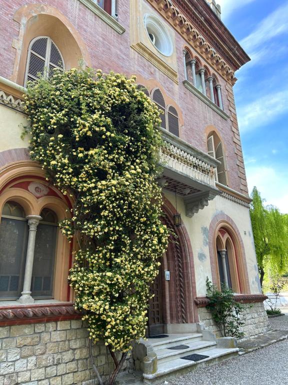 a building with a large bush of flowers on it at Villa Tirotti in Piacenza