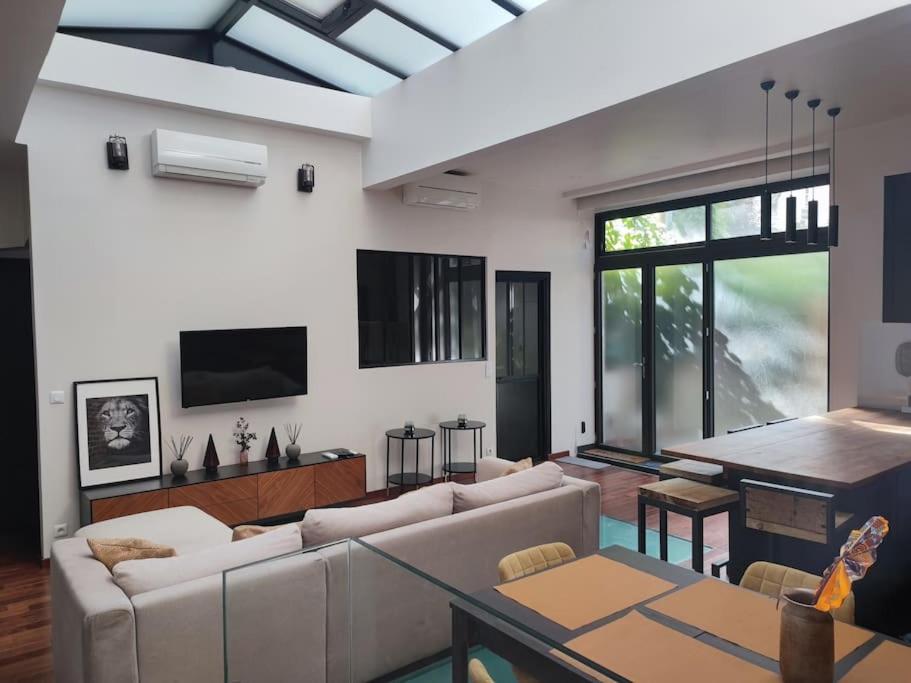 un salon avec un canapé et une table dans l'établissement Loft Paris centre face au parc des buttes Chaumont, à Paris