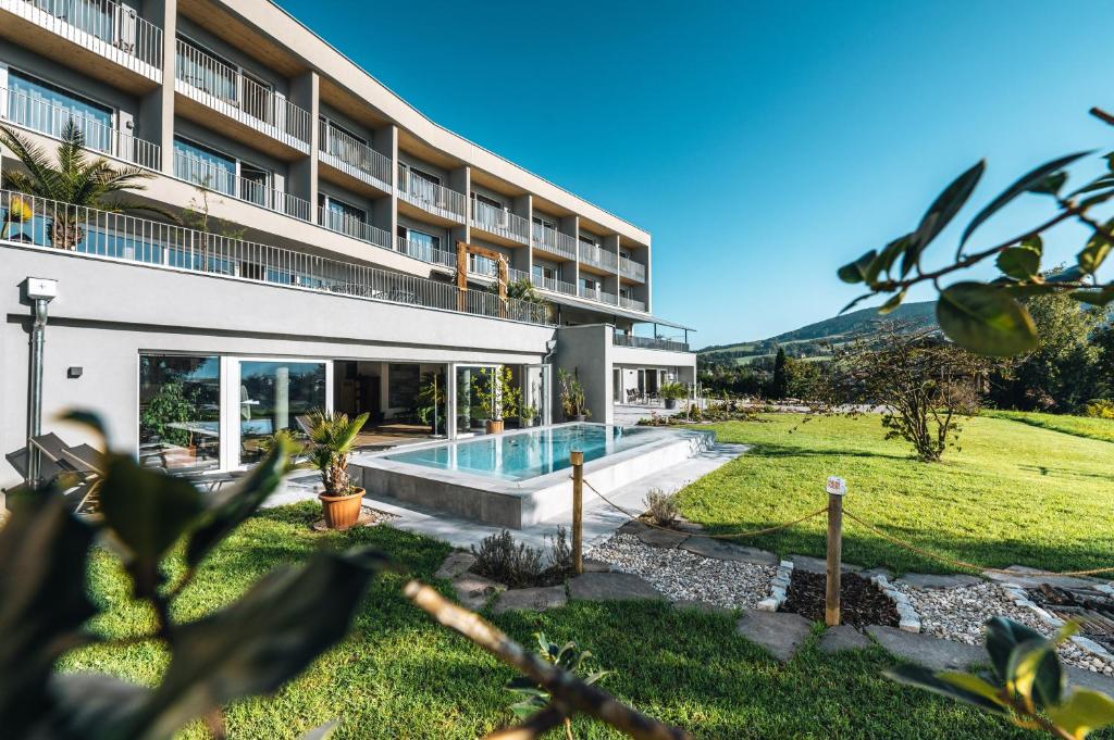 une vue sur l'extérieur d'un hôtel avec une piscine dans l'établissement Landhotel Prielbauer, à Mondsee