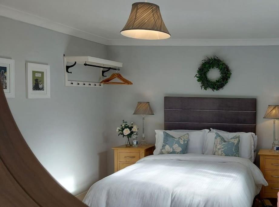 1 dormitorio con 1 cama blanca grande y zona de estar en la pared en The Studio, en Kildare