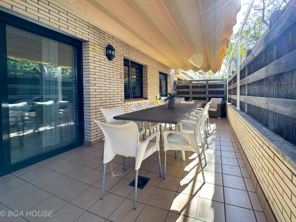 a wooden table and chairs on a patio at Bga Rentals Garbi in Cambrils
