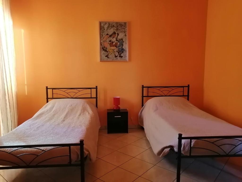 2 camas en una habitación con paredes de color naranja en La Casa di Laura, en Cirié