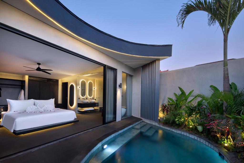 a bedroom with a bed and a swimming pool at Je Ne Sais Quoi Seminyak in Seminyak