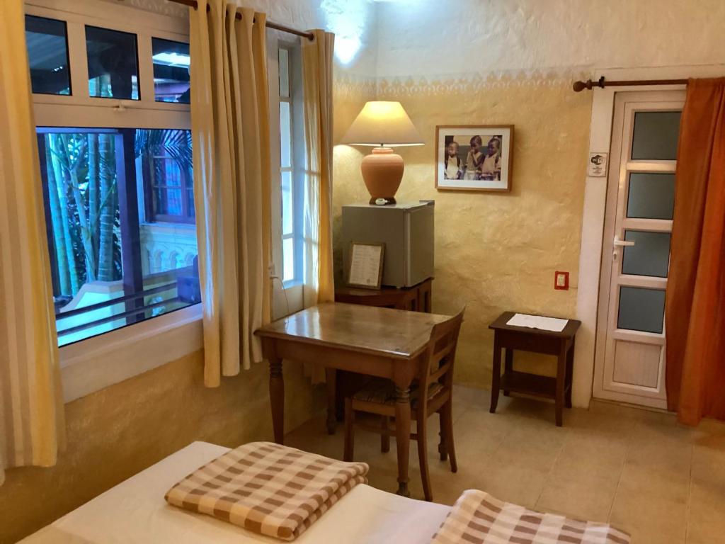 拉高萊特的住宿－拉萊因克里奧爾酒店，一间卧室配有书桌、桌子和窗户。