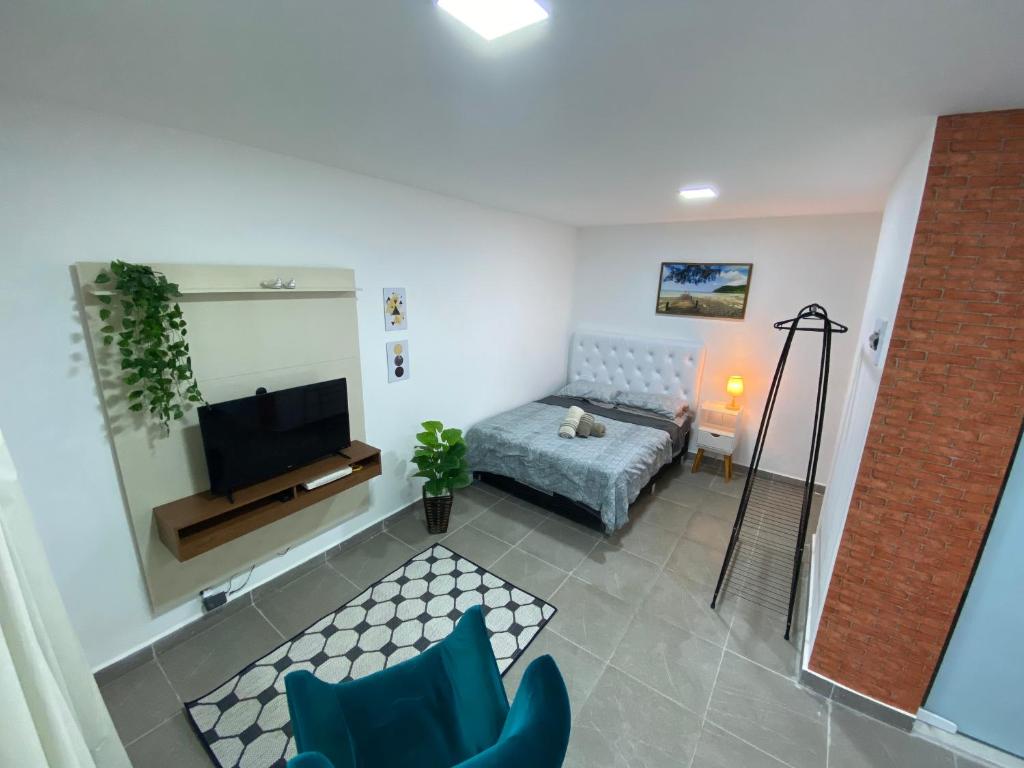 sala de estar con sofá y TV en Suite Vargem Grande 2 - praia, cachoeira e trilhas en Río de Janeiro