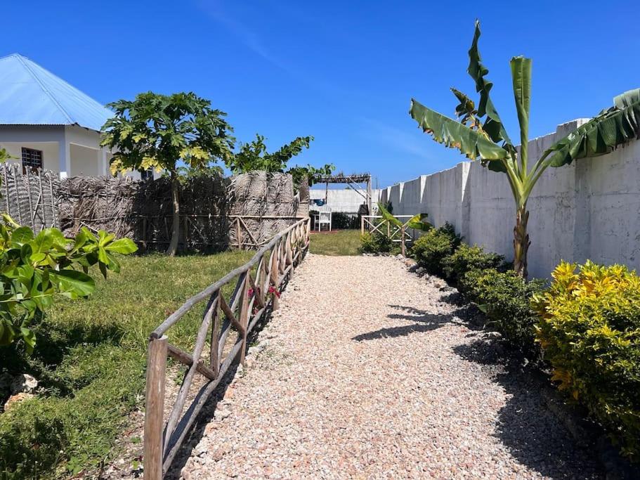 una pasarela junto a una valla junto a una pared en Maïsha House Makundochi Beach, en Makunduchi