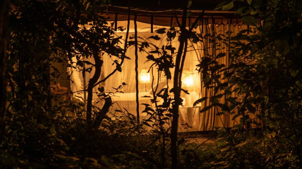 Una casa con luces en la oscuridad en Nje Bush Camp, en Kwangwazi