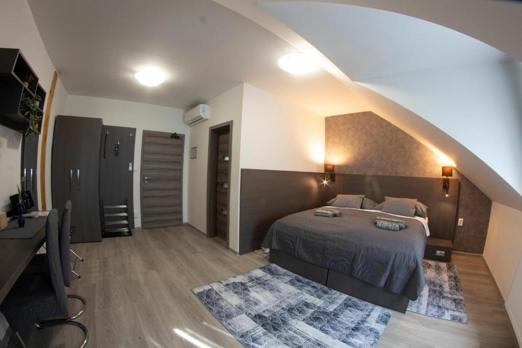 ein Schlafzimmer mit einem Bett und einem Dachgeschoss in der Unterkunft VALLA penzión & reštaurácia in Malacky