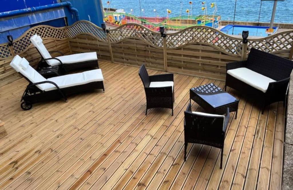 a deck with chairs and tables on a cruise ship at SEA VIEW Apartment Large Balcony Whirlpool Bath 2 Bedrooms SKY GLASS TV in Bridlington