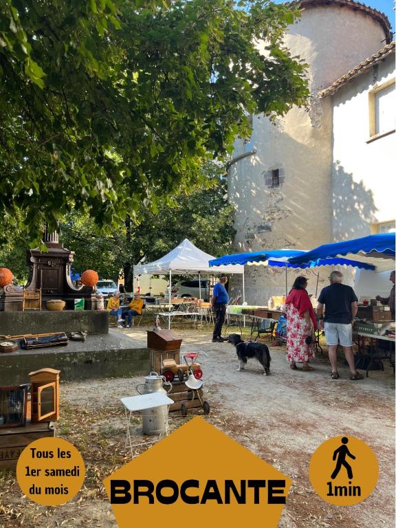 a group of people standing under tents with a dog at La Brocante - Meilleurhote-Brioude in Brioude