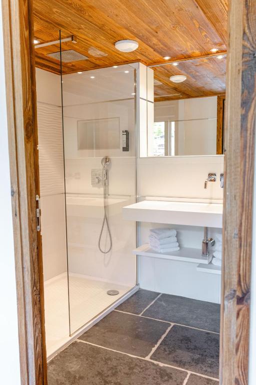 a bathroom with a shower and a sink at Hôtel Alpina &amp; SPA in Les Gets