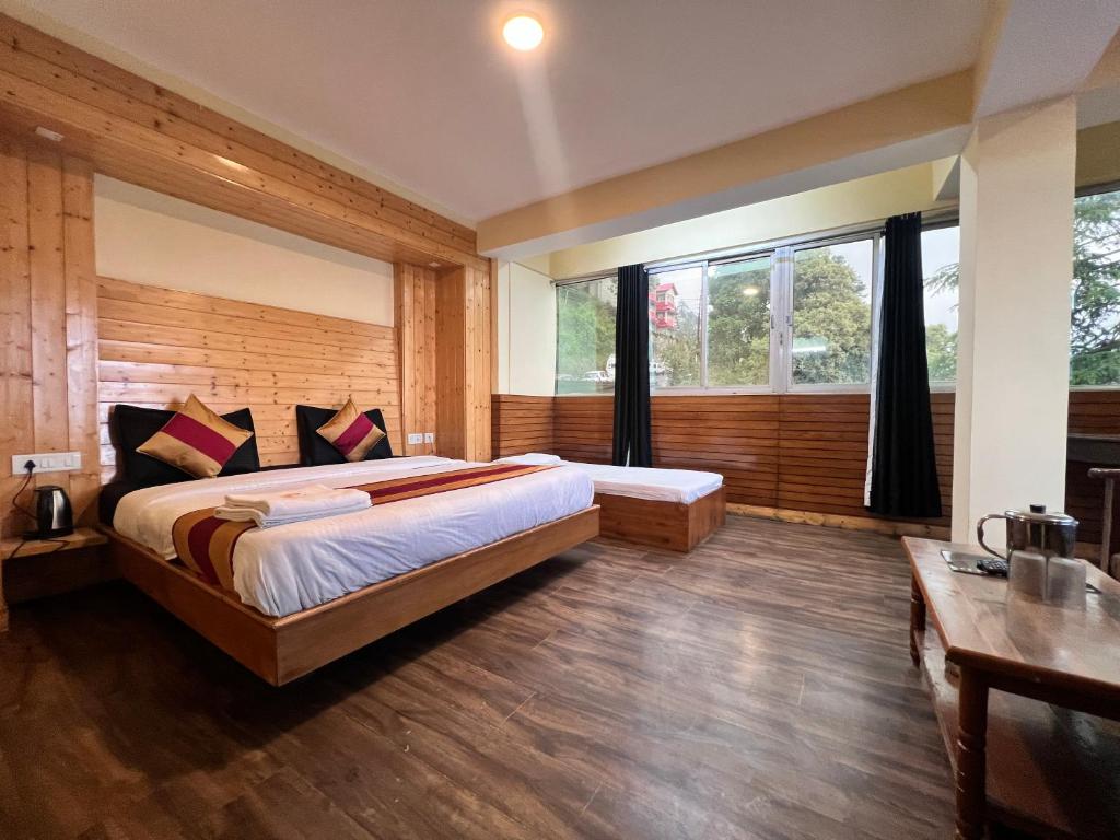 a bedroom with a large bed and a large window at GS COTTAGE ON MALL ROAD in Shimla