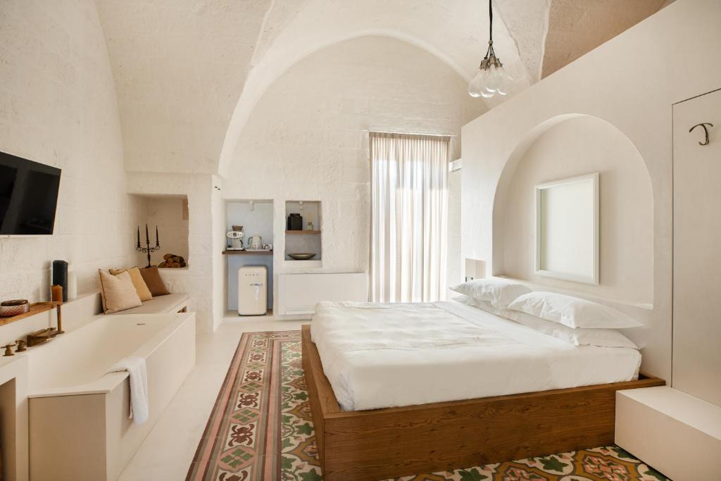 biała sypialnia z dużym łóżkiem i łazienką w obiekcie AL PALAZZO La Dimora by Apulia Hospitality w mieście Fasano