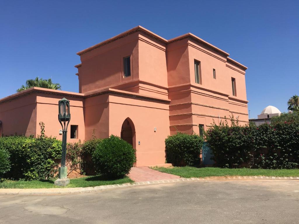 a building with a clock on the side of it at Villa Magnolia - Amelkis Golf in Marrakech