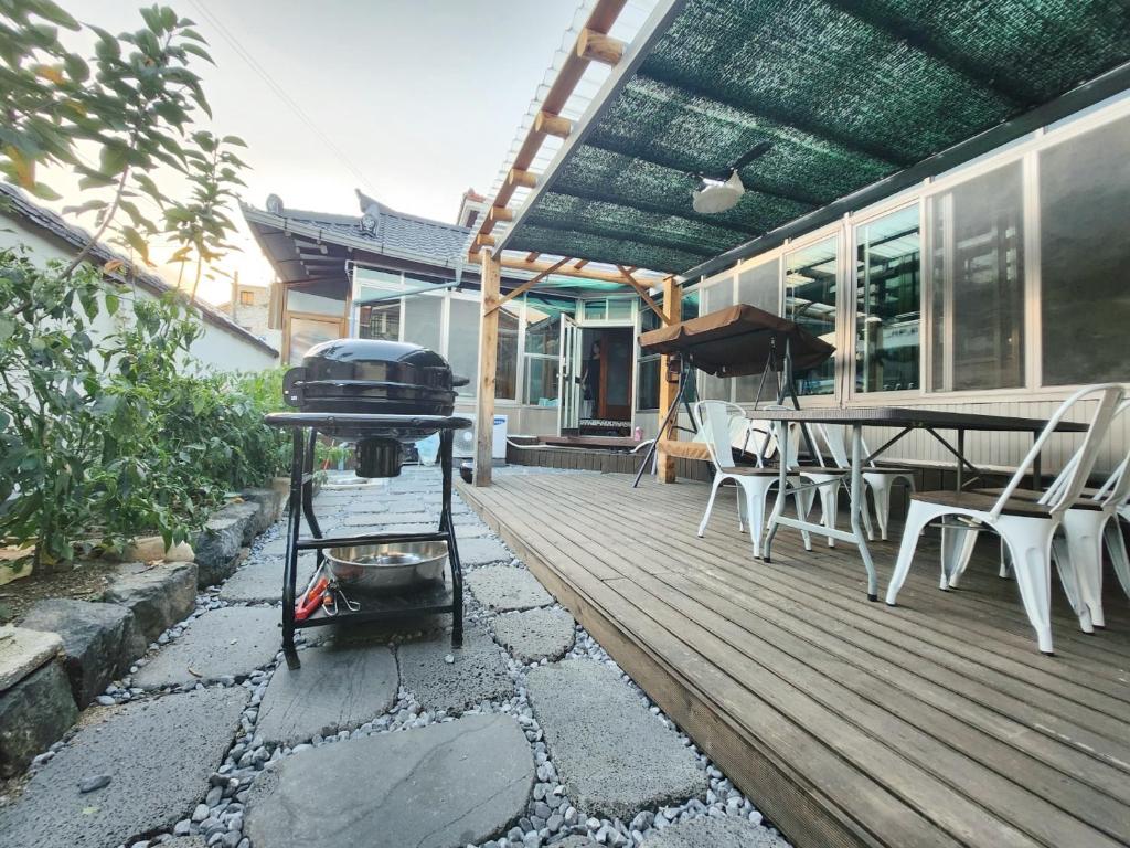 - un barbecue sur une terrasse avec une table et des chaises dans l'établissement Daepung Stay, à Andong