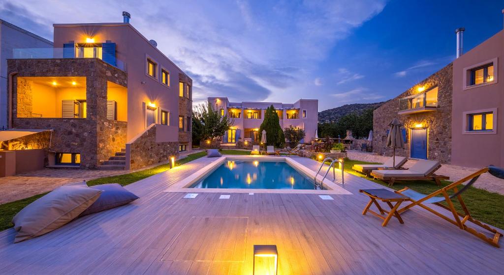 a villa with a swimming pool in front of a building at NJV plus K in Aegina Town
