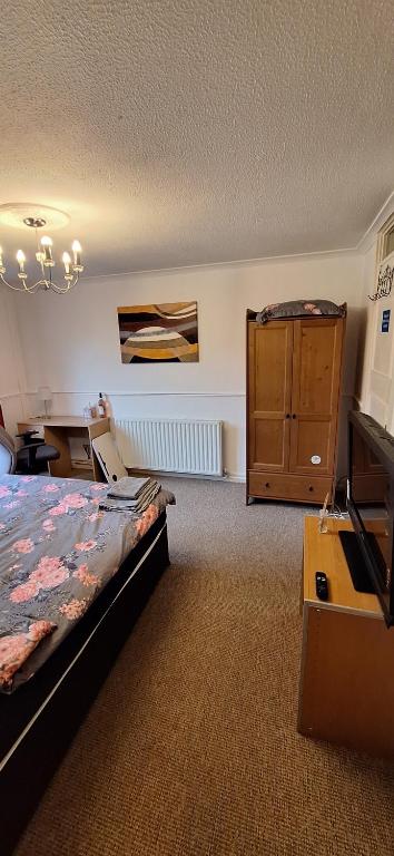 a bedroom with a bed and a dresser in it at Spacious and Serene Stay near Milton Keynes centre in Willen