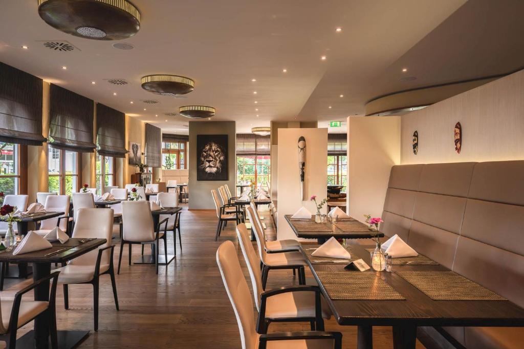 Un comedor con mesas y sillas de madera. en Sunderland Hotel, en Sundern