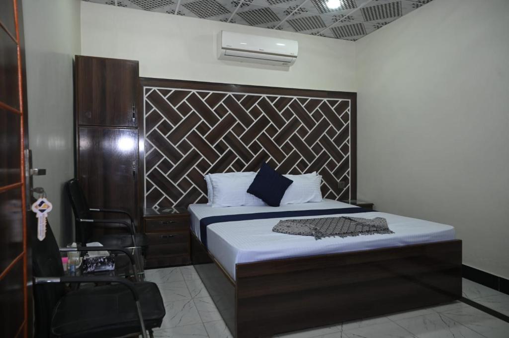 a bedroom with a bed with a wooden headboard at Hotel Serina Inn in Kalar Goth