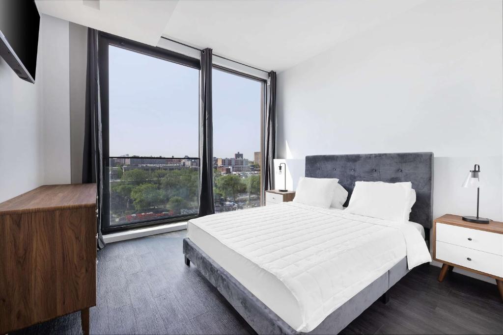 1 dormitorio con 1 cama grande y ventanas grandes en The Bogart by LuxUrban, Trademark Collection by Wyndham, en Brooklyn