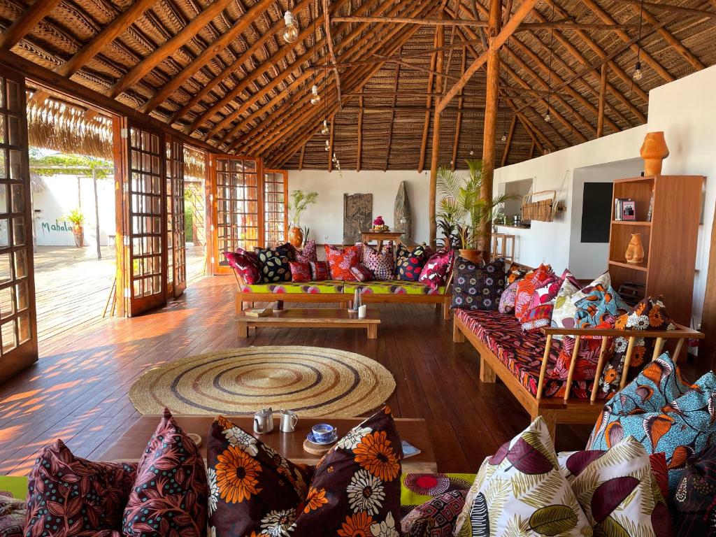 a living room with many couches and a rug at umbila:Barra in Inhambane