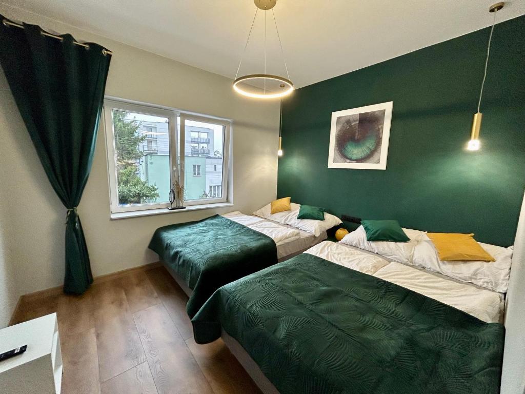 twee bedden in een kamer met een groene muur bij Premium Exclusive Suite in Nowy Dwór Mazowiecki