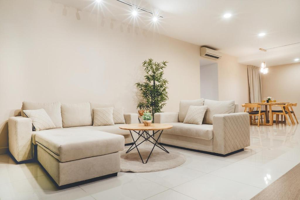 a living room with a couch and chairs and a table at Teega Muji 4BR 12 pax w bathtub by Our Stay in Nusajaya
