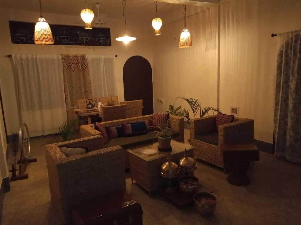 a living room with couches and a table at Globetrotters homestay in Jorhāt