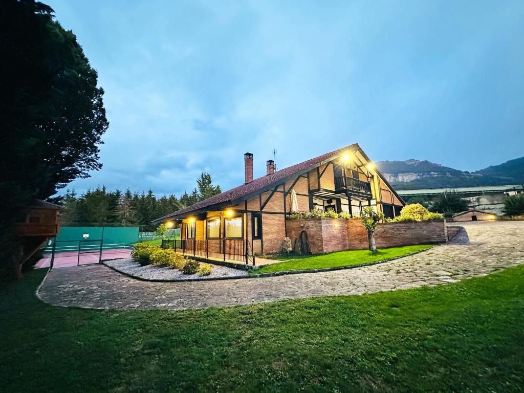 ein großes Backsteinhaus mit eingeschaltetem Licht in der Unterkunft BARANDI URBASA CASA RURAL in Olazagutía