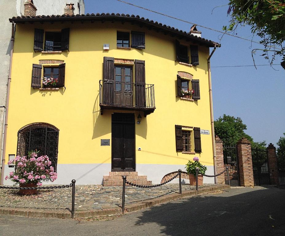 a yellow house with windows and a balcony at Altes Backhaus in Maranzana in Mombaruzzo