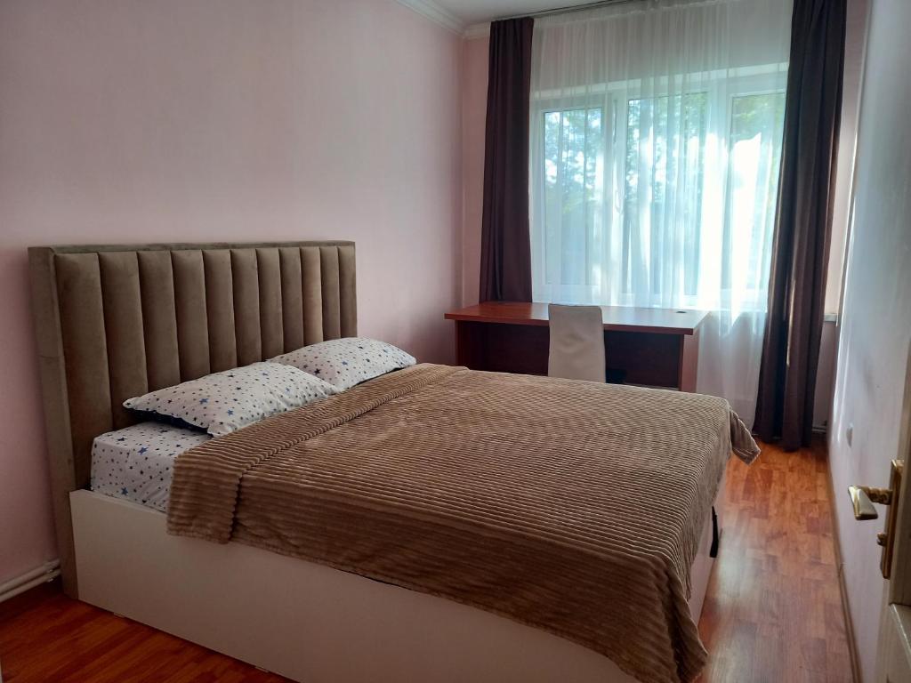 1 dormitorio con 1 cama, ventana y escritorio en Malacia apartments, en Ereván