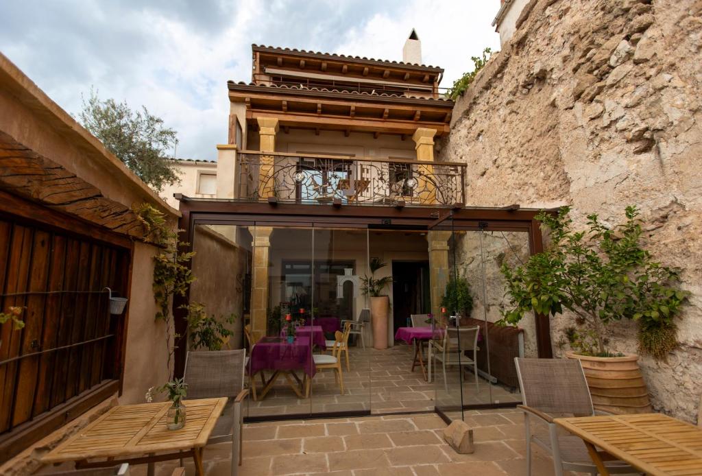 a patio with tables and chairs and a balcony at Hotel Poeta Jorge Manrique in Segura de la Sierra