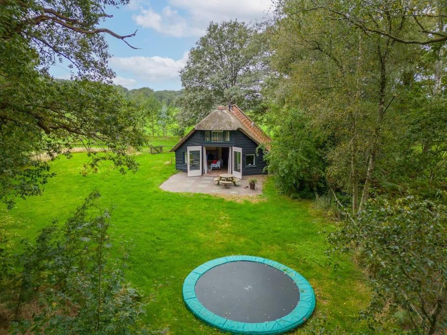an aerial view of a house with a pond in the yard at Prachtig vrijstaand familiehuis op groot perceel in Scherpenzeel
