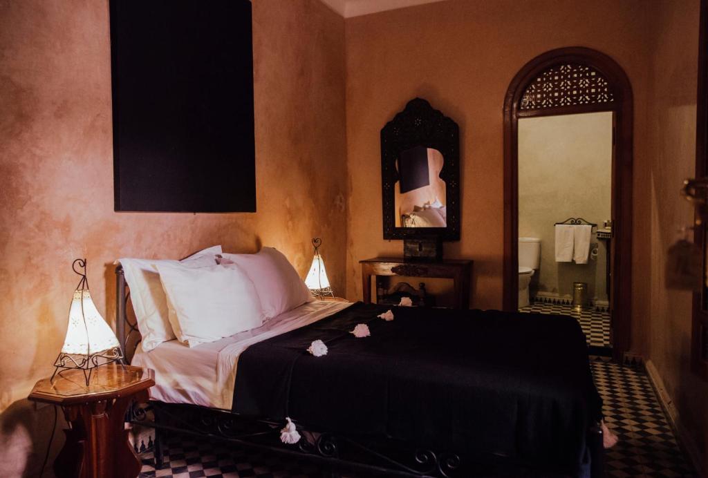 a bedroom with a bed and a large mirror at Riad Bensaid in Marrakech