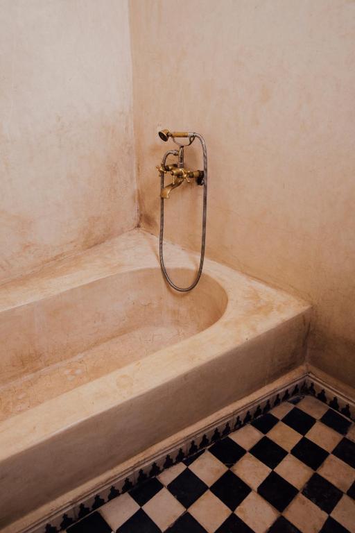 a bath tub with a shower in a bathroom at Riad Bensaid in Marrakech
