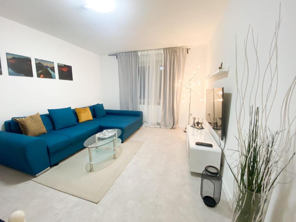 ein Wohnzimmer mit einem blauen Sofa und einem Tisch in der Unterkunft 1-3 Pers. 0,9 km zum Zentrum - moderne Wohnung in Remscheid in Remscheid