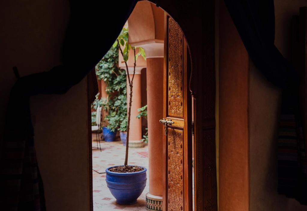 a potted plant in a blue pot next to a building at Riad Bensaid in Marrakech