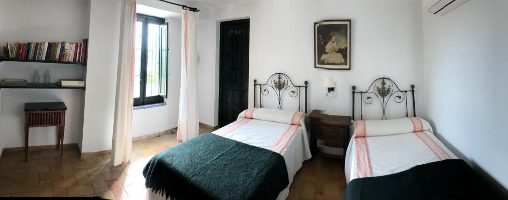1 Schlafzimmer mit 2 Einzelbetten und einem Fenster in der Unterkunft La Capellania de Alvear in Montilla
