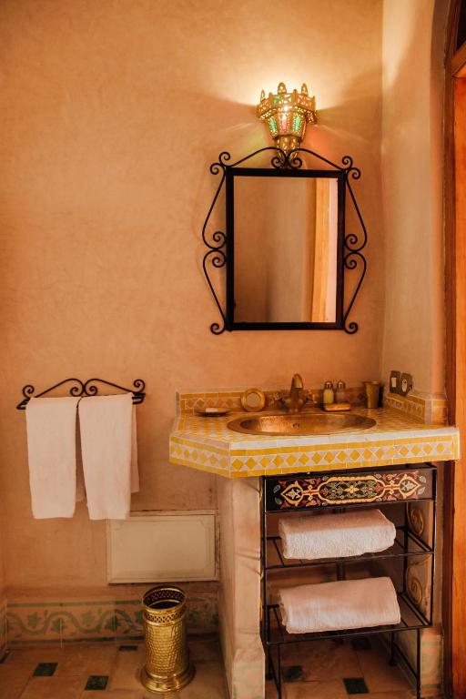 a bathroom with a sink and a mirror and towels at Riad Bensaid in Marrakech