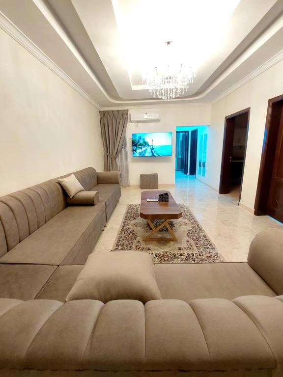 a living room with a couch and a table at شقة واسعة غرفتين نوم وصالة in Tabuk