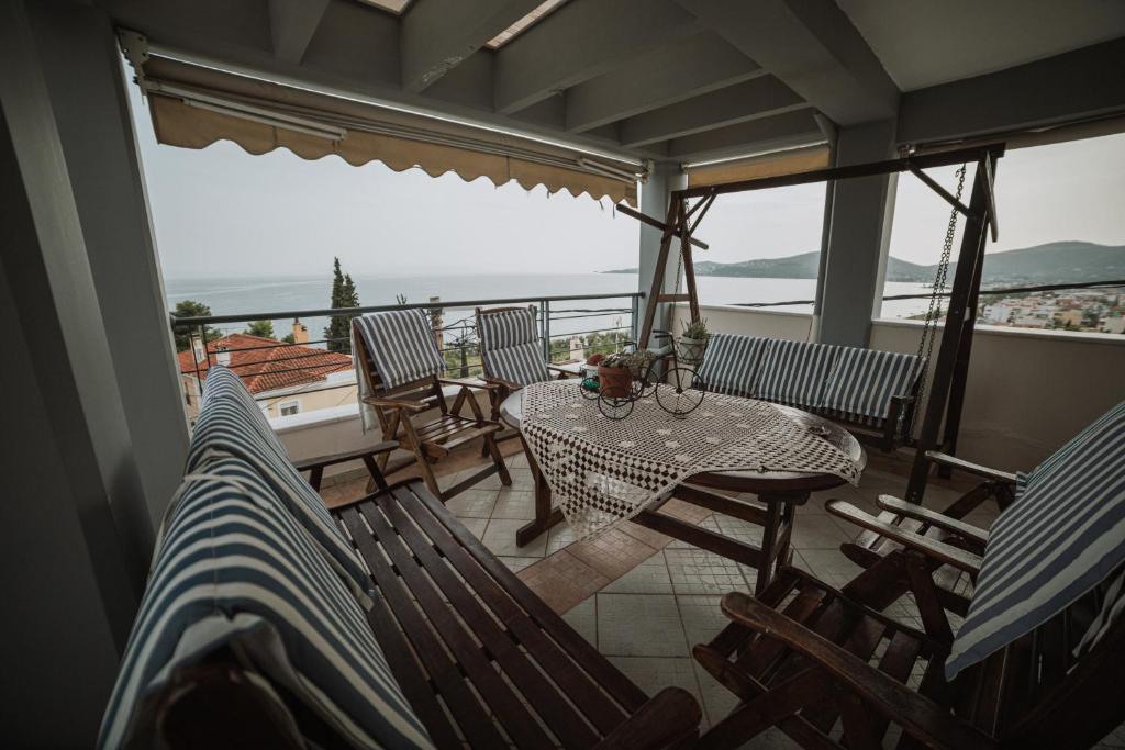 a balcony with a table and chairs and a view of the ocean at Niki House in Volos