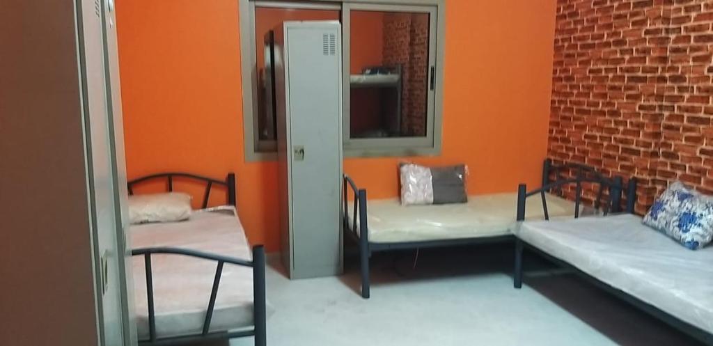 um quarto com duas camas e um espelho em Executive Sharing Bed With Other Male Guests em Sharjah