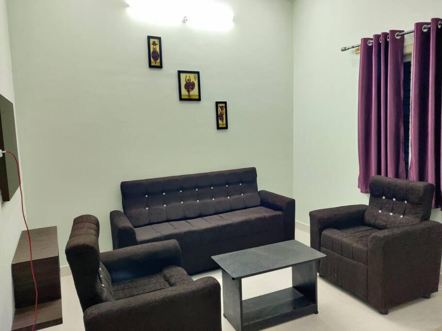 uma sala de estar com um sofá e duas cadeiras em The Home Mars call 8O882-37972 em Mysore