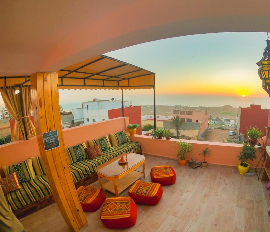 een woonkamer met een bank en uitzicht op de woestijn bij Atlantic Vibes Surf Hostel in Tamraght Ouzdar