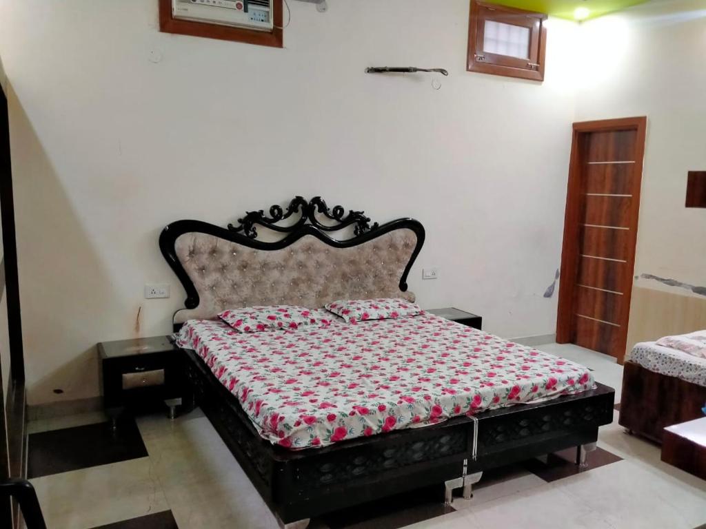 a bedroom with a large bed with a black frame at Vishal AC homestay in Rāja Sānsi