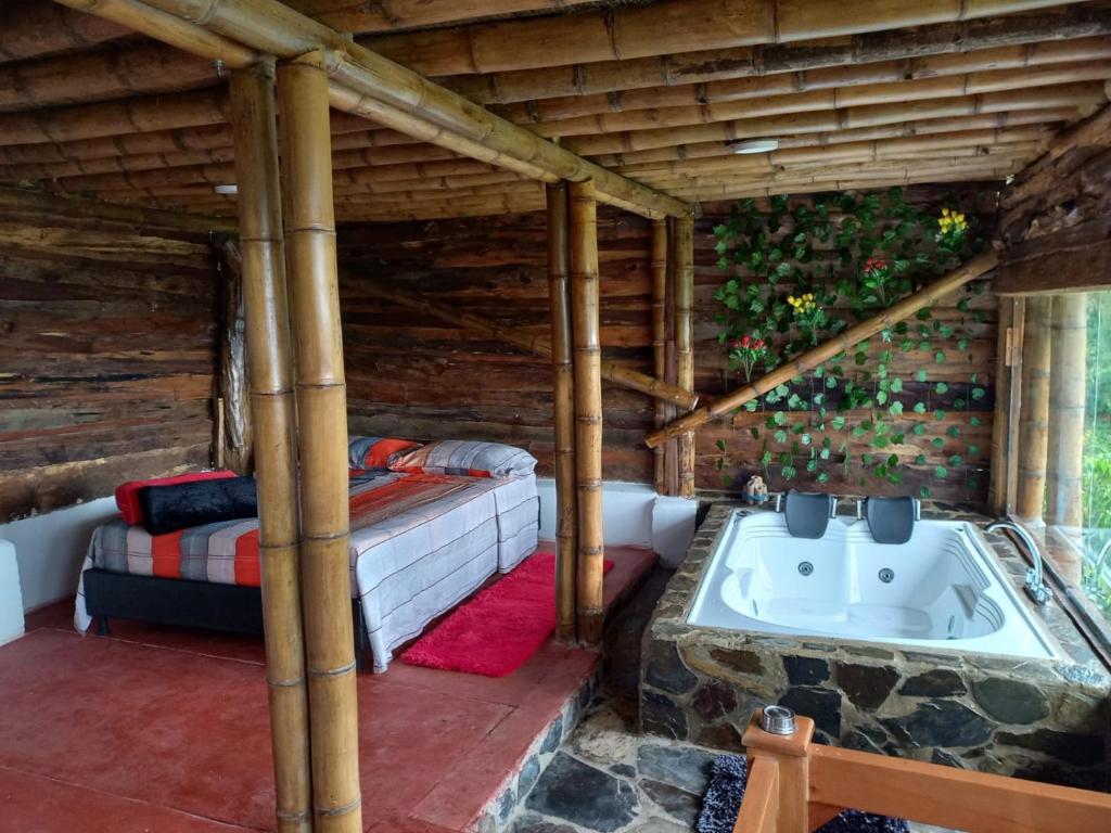 Habitación con cama y bañera. en Preciosa Cabaña alpina en zona rural, en Dosquebradas