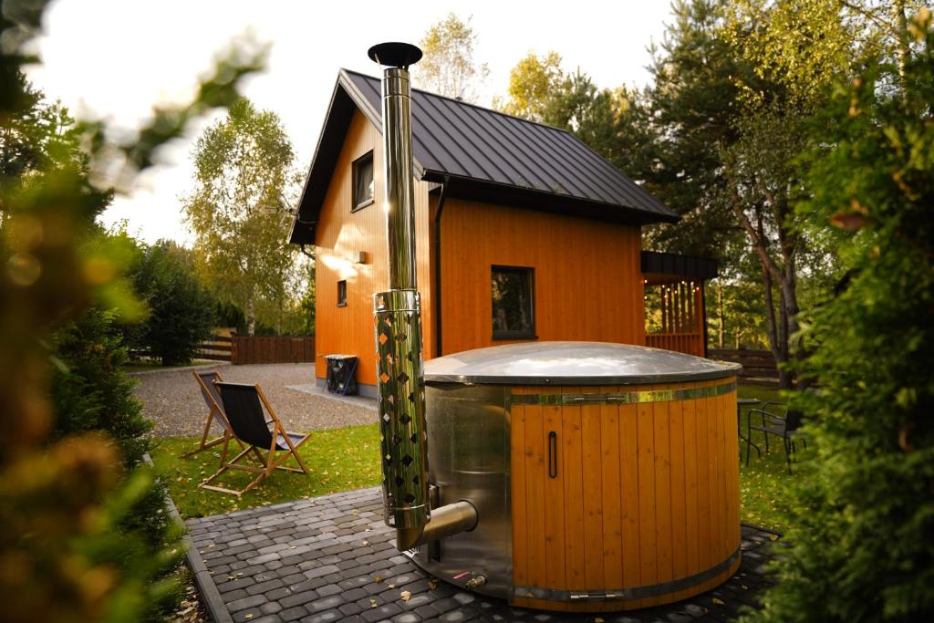 una pequeña casa con bañera de hidromasaje frente a ella en Stacja Alpaka Mały Domek z Balią nad Zalewem Chańcza en Raków